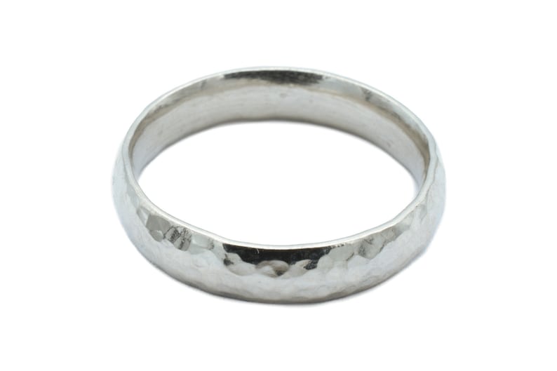 May include: A silver hammered wedding band.