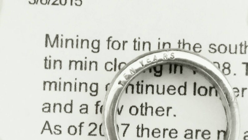 May include: A silver ring with the inscription "Ten Years" on the band.