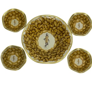 May include: A set of five vintage metal serving dishes. The dishes feature a gold rim and are filled with peanuts. The center of each dish has a Mr. Peanut character illustration.