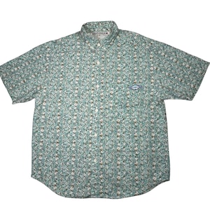 May include: Short-sleeved button-down shirt with a repeating pattern of green and white shapes. The shirt has a small blue and white logo on the chest and the word "BOTCHAS" on the collar.