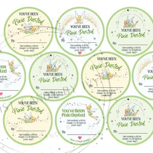 Könnte beinhalten: Eine Sammlung runder Aufkleber mit Feen-Motiven. Jeder Aufkleber zeigt eine Feen-Illustration, den Text "You've Been Pixie Dusted" und Platz zum Schreiben eines Namens. Die Aufkleber sind in Grün-, Gelb- und Weißtönen gehalten.