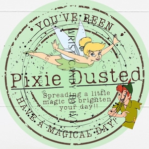 May include: A circular light green sticker featuring Tinker Bell and Peter Pan. Text reads: YOU'VE BEEN Pixie Dusted! Spreading a little magic to brighten your day!! HAVE A MAGICAL DAY! The design includes a dark brown circular stamp border.
