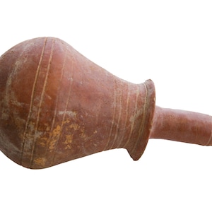 May include: A terracotta clay pot with a rounded body and a long, narrow spout. The pot has a rustic, aged appearance with visible lines and imperfections.