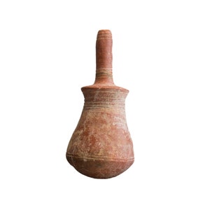 Peut inclure: Une cruche en poterie de terre cuite avec un col étroit et un corps arrondi. La cruche a un design simple avec des lignes gravées autour du col et du corps.