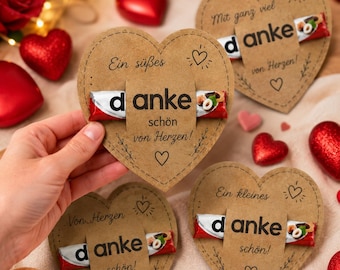 May include: Heart-shaped kraft paper cards featuring a chocolate bar held in the center. Each card displays the German text "danke schön von Herzen" or "Mit ganz viel danke von Herzen" with decorative line drawings of hearts and small floral sprigs.