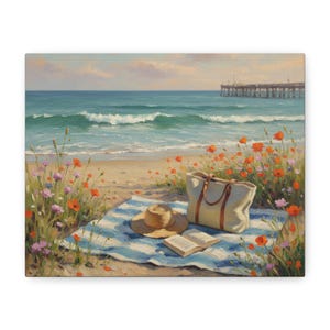 May include: A beach scene painting depicts a sunny day with a blue and white striped blanket, straw hat, open book, and a beige tote bag. Orange and pink wildflowers frame the scene, with the ocean and a pier in the background.