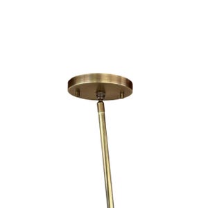 May include: A circular antique brass ceiling canopy with a brushed metallic finish, featuring two small side screws and a central swivel joint connected to a slender, matching brass rod that extends downward for a light fixture installation.