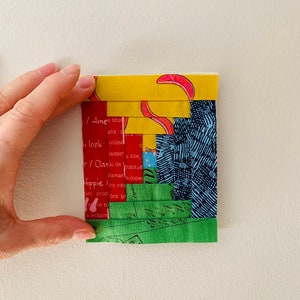 May include: A multi-colored fabric block with a patchwork design. The block is made of five different fabrics, including yellow, red, blue, green, and white. The fabrics are sewn together in a random pattern, creating a unique and interesting design. The block is about 6 inches square.