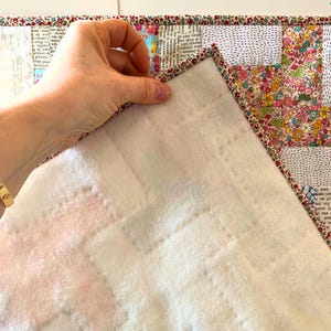 Windmill patchwork baby quilt pattern, Jelly roll friendly beginner crib blanket sewing tutorial PDF, hand quilting detail on micro fleece background