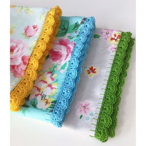 May include: Three tea towels with floral patterns and crocheted trim. The towels are in shades of blue, green, and yellow.