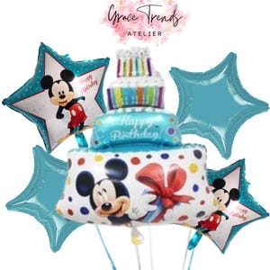 May include: A collection of blue and white Mickey Mouse-themed balloons. The centerpiece is a cake-shaped balloon with the words "Happy Birthday!" and a large Mickey Mouse balloon. Star-shaped balloons and the text "Grace Trends Atelier" are also visible.