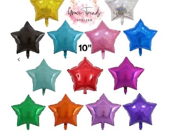 Può includere: Una collezione di tredici palloncini in alluminio a forma di stella in vari colori, tra cui oro, argento, nero, blu, rosa, rosso, viola, verde e arancione. Ogni palloncino misura 25,4 cm. Il testo Grace Trends ATELIER è centrato in alto.