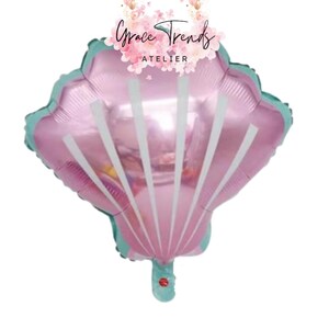 May include: A pink seashell-shaped balloon with white vertical stripes and a teal border. The balloon has a valve at the bottom and the text "Grace Trends ATELIER" at the top.