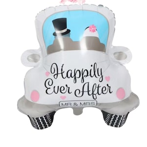 May include: White car-shaped balloon with the text "Happily Ever After" and "MR & MRS". The balloon features a bride and groom illustration inside the car window, with pink heart accents and black and white tire detailing.