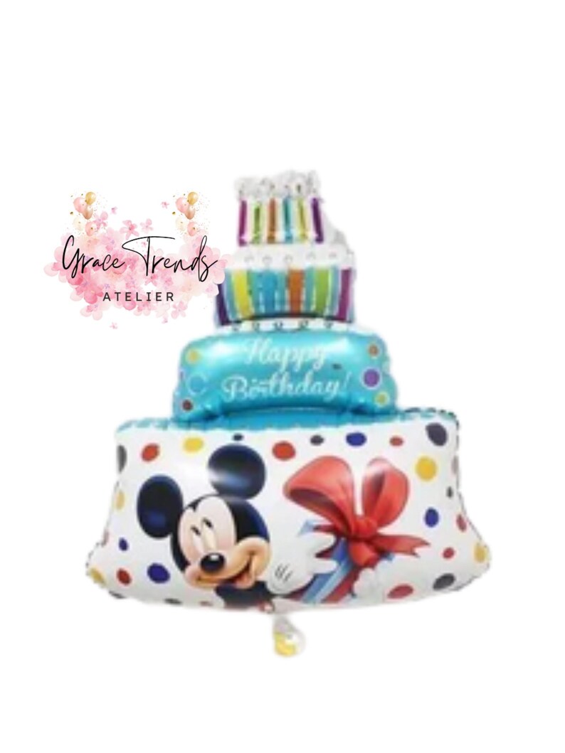 May include: A three-tiered birthday cake balloon featuring Mickey Mouse, a red bow, and colorful polka dots. The middle tier reads "Happy Birthday!" in blue. The top tier has candles. The balloon is white, blue, and multi-colored.