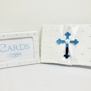 May include: White card box with a blue cross and the words "CARDS" on a white frame. The box and frame are decorated with rhinestones.