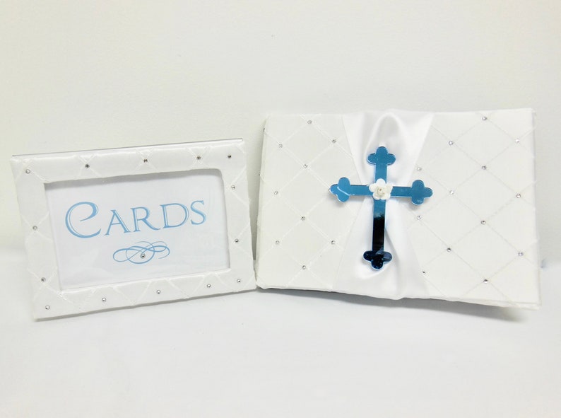 May include: White card box with a blue cross and the words "CARDS" on a white frame. The box and frame are decorated with rhinestones.
