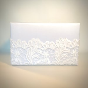 May include: White box with a lace trim around the bottom edge.