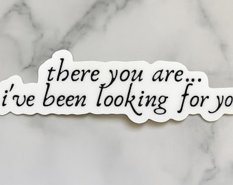 May include: A white sticker with black cursive text that reads "there you are... I've been looking for you." The sticker has a unique, irregular shape and is set against a marble background.