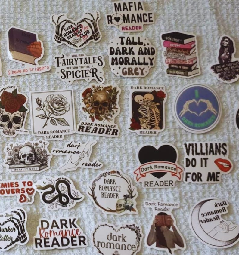 May include: A selection of stickers with a dark romantic theme. Designs include skulls, roses, skeletons, and phrases such as "Dark Romance Reader," "Villains Do It For Me," and "Mafia Romance Reader." The stickers are in various shapes and sizes.