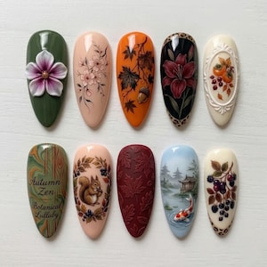 May include: Ten artificial nails with diverse designs. The designs feature floral patterns, autumn leaves, a squirrel, a koi pond scene, and the text "Autumn Zen Botanical Lullaby". Colours include green, orange, pink, and burgundy.