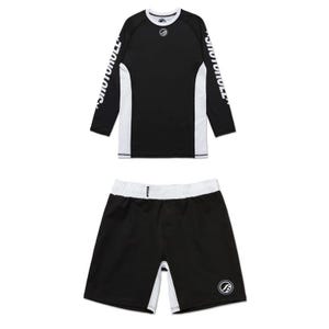 Könnte beinhalten: Schwarzes und weißes Sport-Rashguard-Set. Das langärmlige Oberteil hat weiße Seitenteile und das Wort "SHOTOKU" auf den Ärmeln. Die passenden Shorts haben einen weißen Bund und Seitenteile. Ein kreisförmiges Logo befindet sich auf Oberteil und Shorts.
