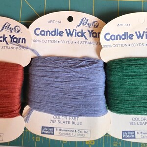 Può includere: Tre cartoncini di filato Lily Candle Wick, ciascuno contenente 30 iarde di filo 100% cotone. I colori sono 131 Russet, 752 Slate Blue e 183 Leaf Green. Ogni cartoncino riporta il marchio, il numero articolo 514 e la solidità del colore.