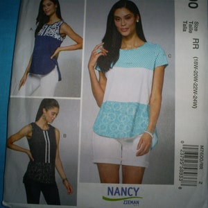 May include: A sewing pattern featuring three different tops. The tops are modeled on a woman wearing white shorts. The tops include a navy blue top with white embroidery, a black top with white stripes, and a white top with turquoise accents. The pattern is labeled "NANCY ZIEMAN".