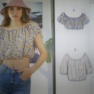 May include: A sewing pattern for a women's off-the-shoulder top with a gathered neckline. The pattern includes three different styles: A, B, and C. The pattern is for sizes XS-S-M.