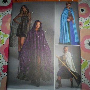 May include: A sewing pattern sheet featuring hooded capes in various styles. The capes are shown in black lace, shimmering purple, and light blue velvet. The pattern includes options for different lengths and fabrics, suitable for costumes or special occasions.