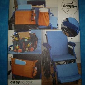 May include: Image of a wheelchair with various adaptive accessories. Includes a blue seat, orange storage pouches, a floral patterned bag, and a cup holder. The text "Adaptive" and "easy-to-sew" are visible.