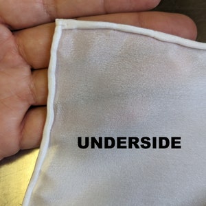Pode incluir: Tecido branco com uma borda branca, mostrando o avesso do tecido. A palavra "UNDERSIDE" est&aacute; impressa em preto no tecido.