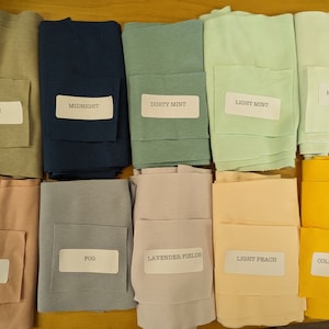 May include: Ten fabric swatches in various colors, including stone, midnight, dusty mint, light mint, hint of mint, mellow rose, fog, lavender fields, light peach, and college yellow.