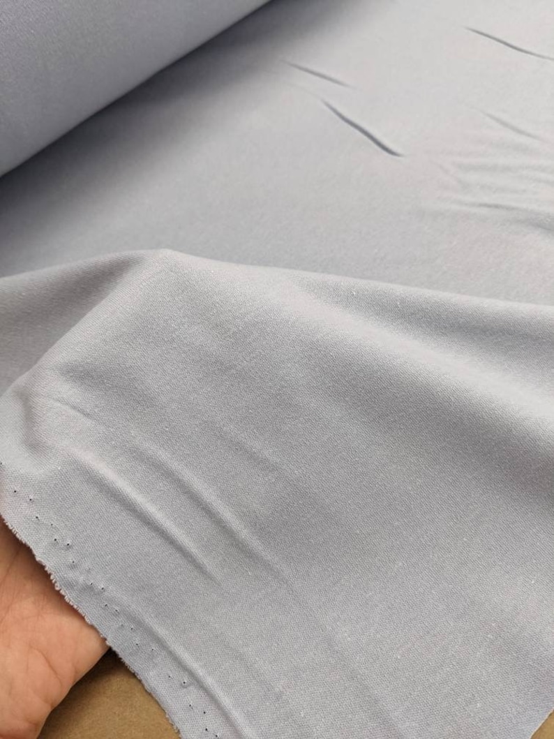 May include: A light blue fabric with a soft, textured surface. The fabric is folded and appears to be a knit material.