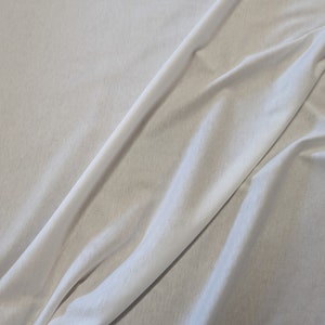 May include: White fabric with a smooth texture and a soft drape.