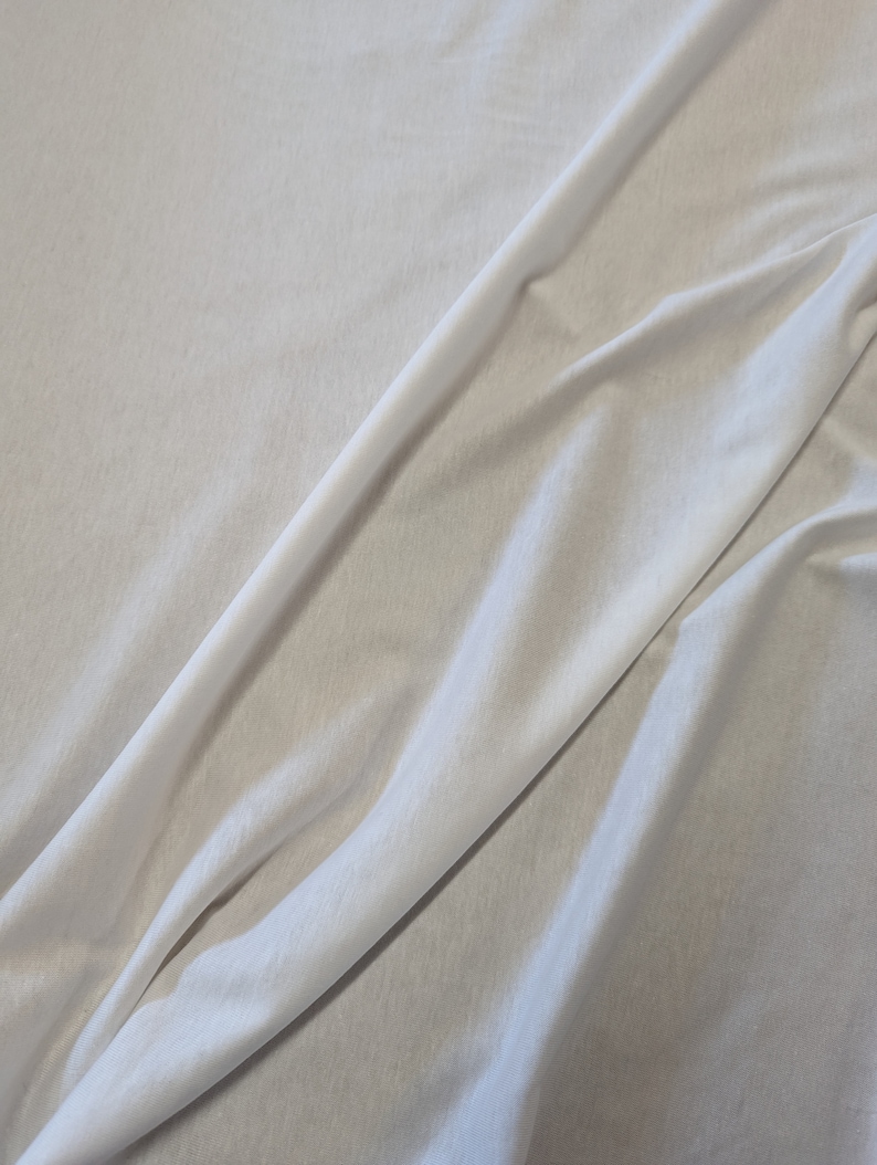 May include: White fabric with a smooth texture and a soft drape.