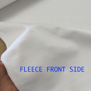 Pu&ograve; includere: Tessuto in pile bianco con la scritta "FLEECE FRONT SIDE" stampata su di esso.