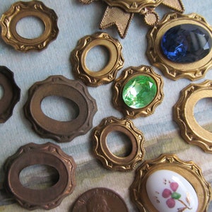May include: Assortment of gold-toned metal oval-shaped frames with decorative edges. Some frames have clear glass or plastic inserts, while others have colourful stones or a white porcelain insert with a pink flower design.