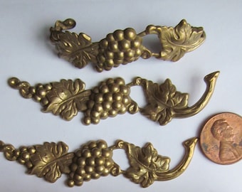 Könnte beinhalten: Drei goldfarbene Metall-Weinreben-Verzierungen mit Blättern und Trauben. Die Verzierungen sind etwa 5 cm lang und perfekt, um Ihren Bastel- und Heimdekorprojekten einen Hauch von Vintage-Charme zu verleihen.