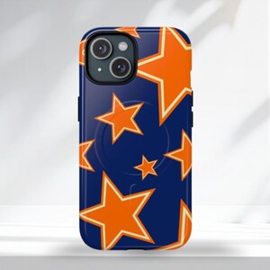 Op de afbeelding: Een marineblauwe telefoonhoes met een patroon van oranje sterren met witte contouren. De hoes heeft een zwarte cameramodule en een donkerblauwe rand. Het ontwerp toont sterren van verschillende groottes.