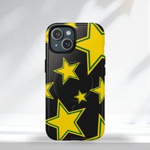Op de afbeelding: Zwarte smartphonehoes met een herhaald patroon van gele sterren met groene contouren. De hoes heeft een camera en een pop-up grip aan de achterkant.