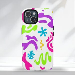 Könnte beinhalten: Weißes Handycase mit einem farbenfrohen, abstrakten Design. Das Case zeigt ein Muster aus leuchtend pinken, lila, grünen und gelben Formen. Das Handycase hat ein schwarzes Kameramodul.