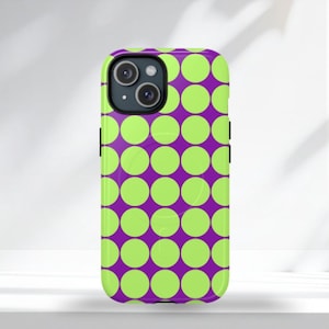 Puede incluir: Funda de teléfono con un vibrante patrón de lunares verde lima sobre un fondo morado oscuro. La funda tiene un acabado brillante y un recorte para la cámara. Diseñada para un teléfono inteligente.