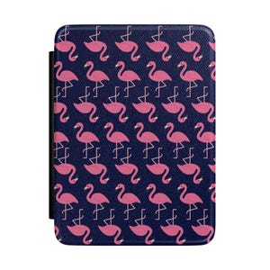 May include: A navy blue e-reader cover featuring a repeating pattern of pink flamingos. The cover has a black spine and a textured appearance. The flamingo design is a fun and colorful accessory for e-readers.