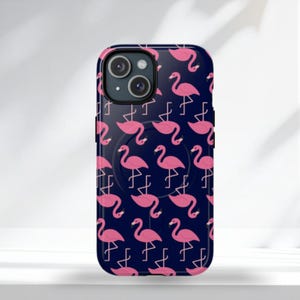Op de afbeelding: Een marineblauwe telefoonhoes met een herhalend patroon van roze flamingo's. De hoes heeft een ingebouwde pop-up grip. De telefoonhoes is ontworpen voor een smartphone.