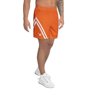 May include: Orange athletic shorts with white diagonal stripes and a small white logo. The shorts are made of a lightweight material and have an elastic waistband. Perfect for running, training, or casual wear.