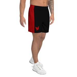 May include: Black athletic shorts with a red side panel and a red bird logo. The shorts are made of a lightweight material and have an elastic waistband. The shorts are designed for athletic activities.