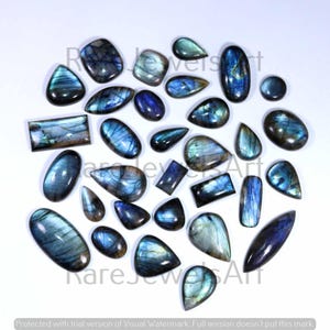 Puede incluir: Una colección de piedras preciosas de labradorita pulidas en varias formas, incluyendo ovaladas, de lágrima y rectangulares. Las piedras muestran tonos iridiscentes azules, verdes y grises. La imagen está sobre un fondo blanco.