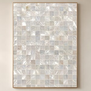 Könnte beinhalten: Ein rechteckiges Wandkunstwerk mit einem Mosaikdesign. Das Mosaik besteht aus zahlreichen kleinen, quadratischen Fliesen in Weiß-, Creme- und schillernden Perlglanztönen. Die Fliesen sind in einem Raster angeordnet und von einem dünnen, hellbraunen Rahmen umgeben.