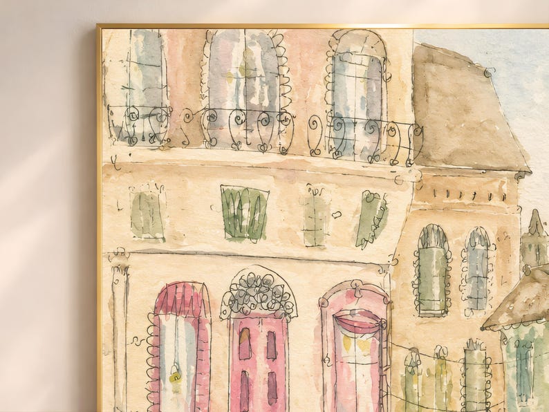 Close-up detail of Parisian watercolor wall art showing ornate pink doors, green shutters, and warm cream building facades